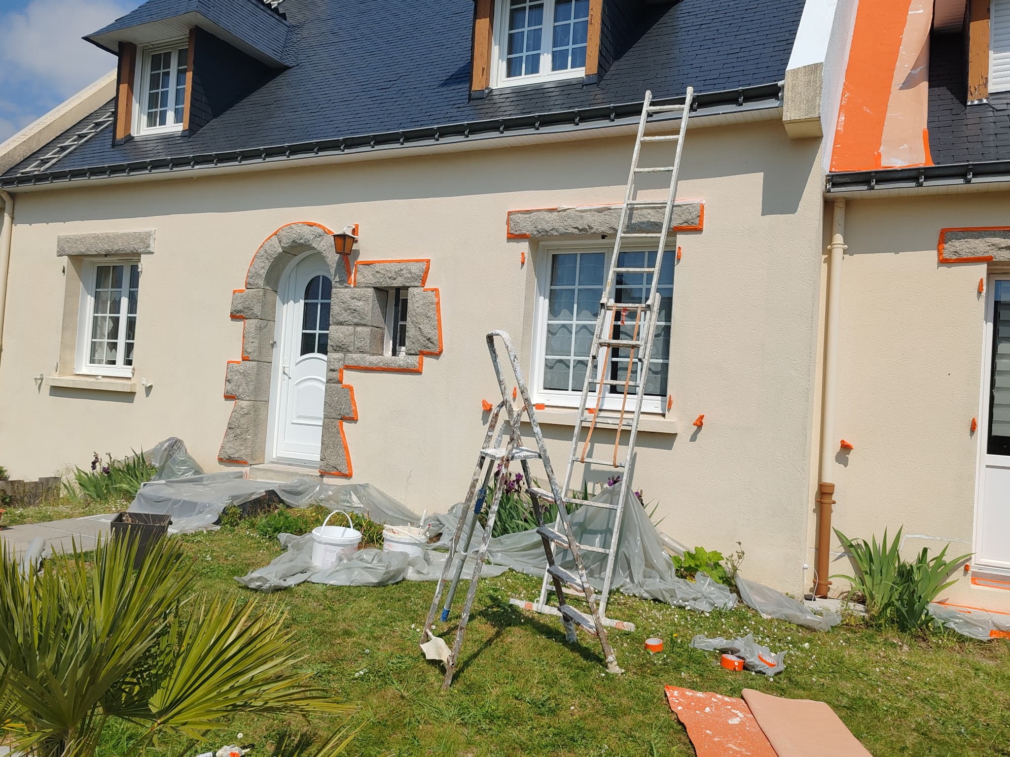 Ravalement de façade en cours, encadrements scotchés, échafaudage